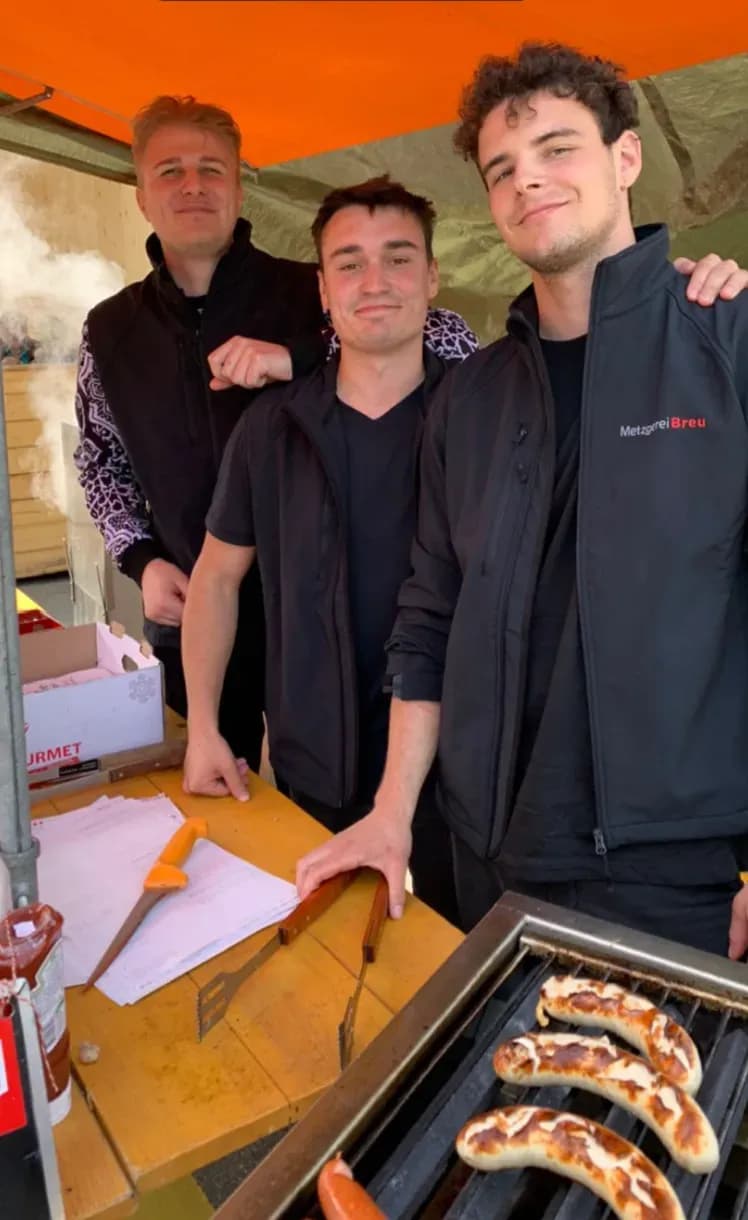 Das Team der Metzgerei Breu mit einer frisch gefertigten Wurst